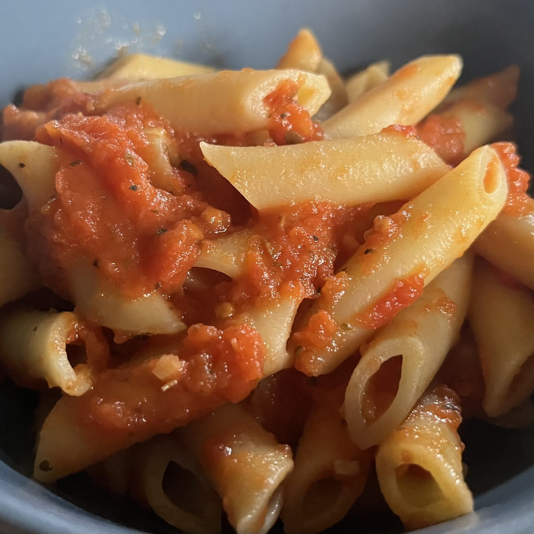 tomato sauce on penne pasta in a bowl