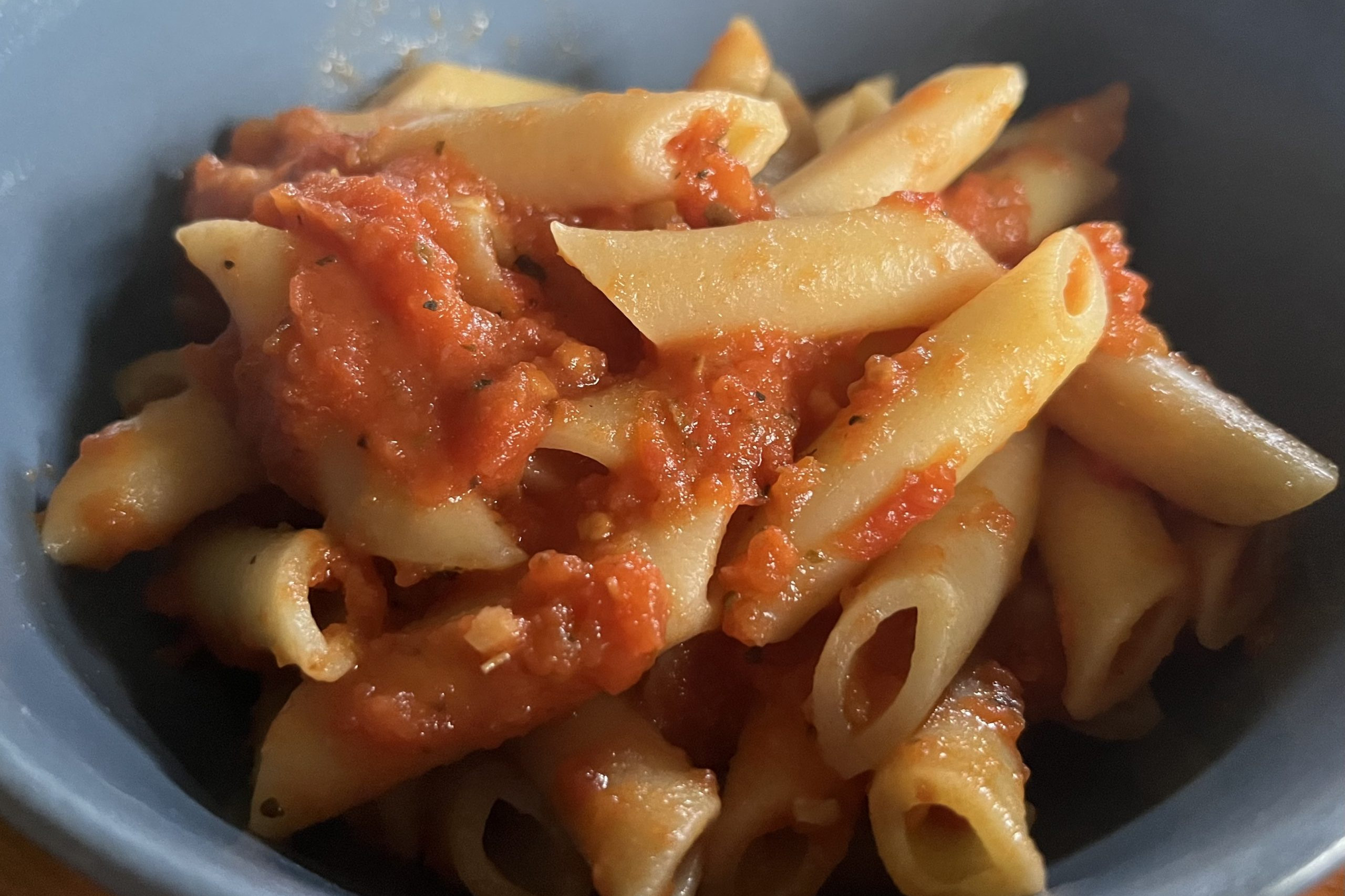 tomato sauce on penne pasta in a bowl