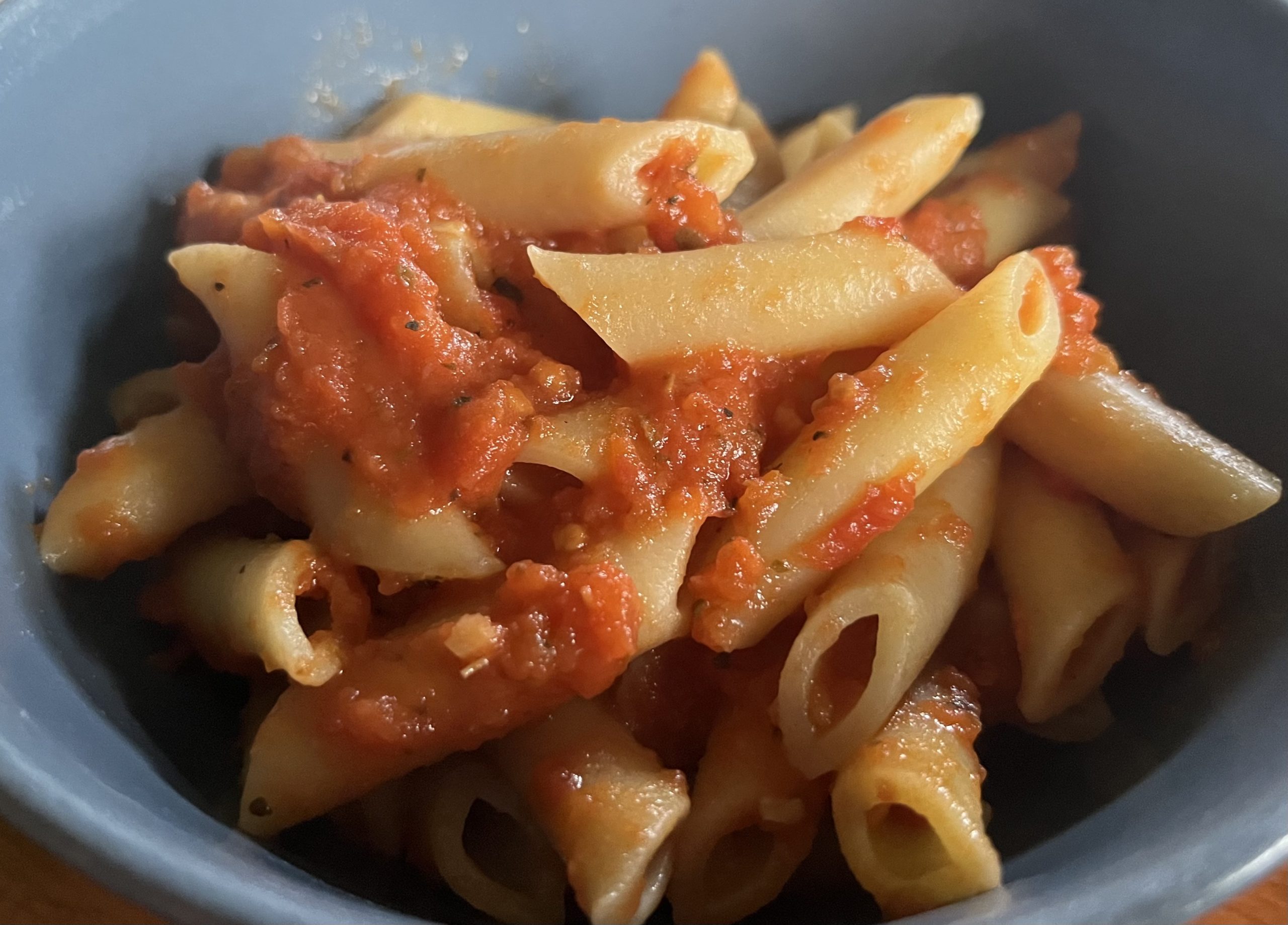 tomato sauce on penne pasta in a bowl