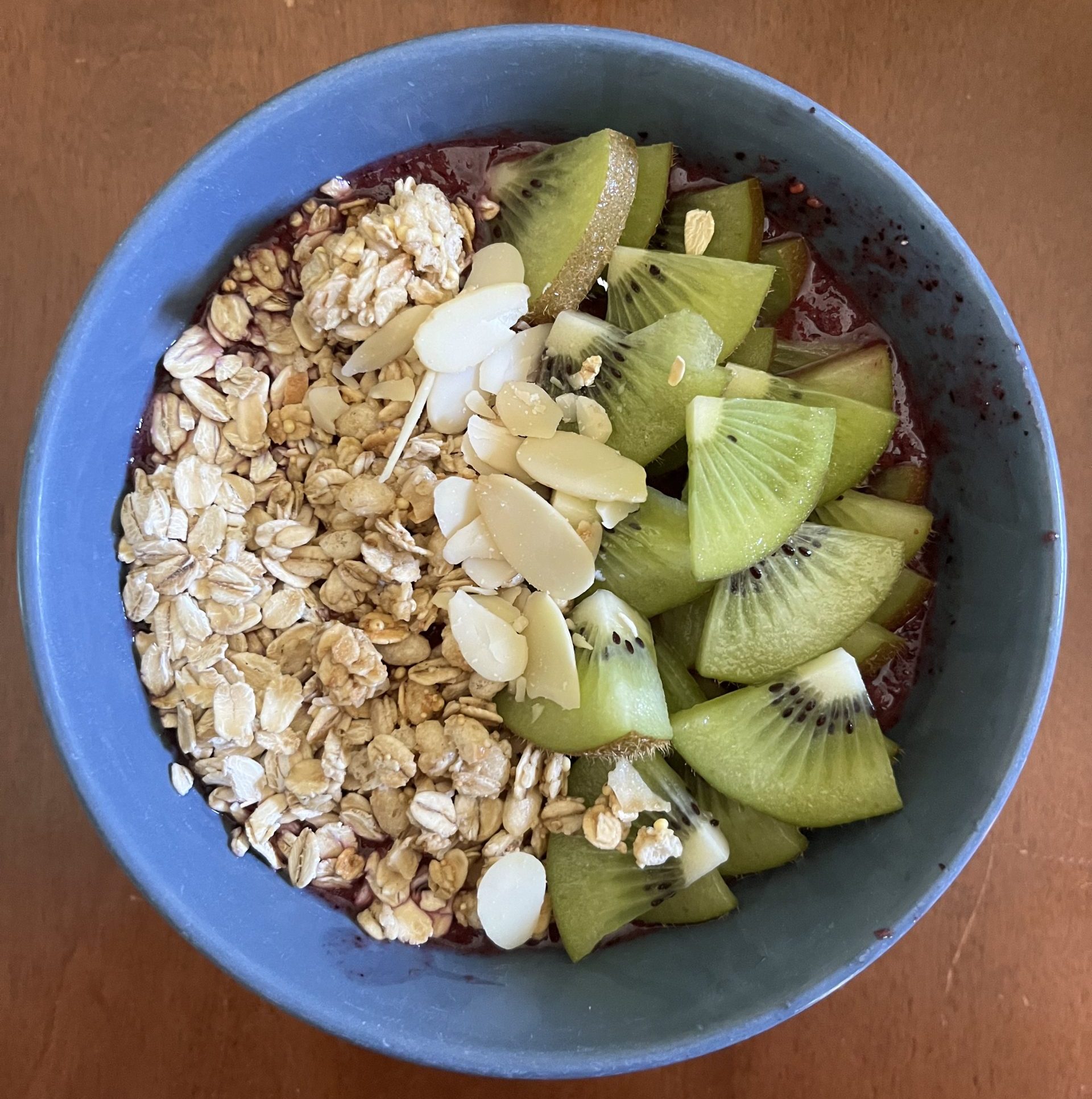 smoothie bowl with chopped nuts, fruit, and oats