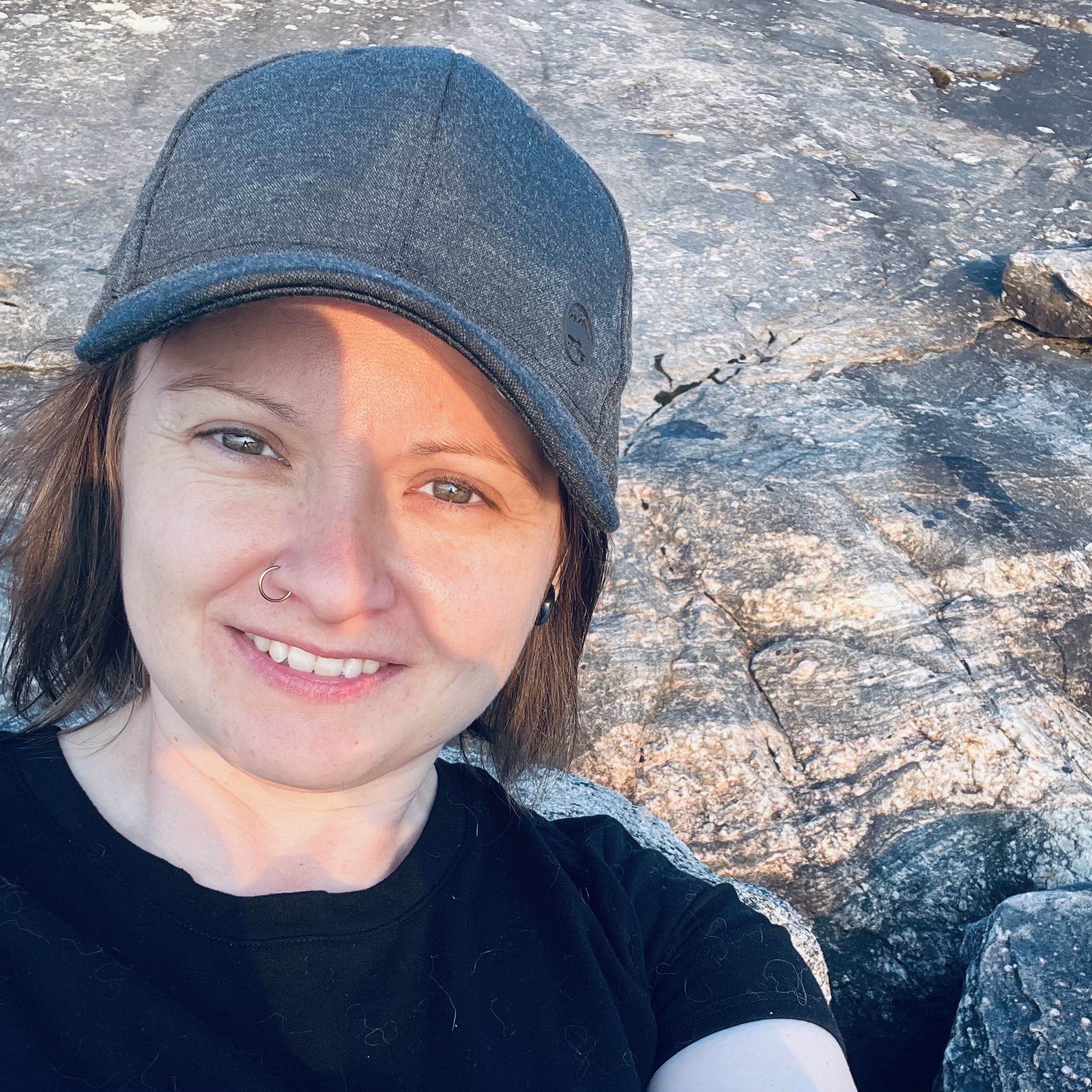 person with a ballcap with rocks in the background