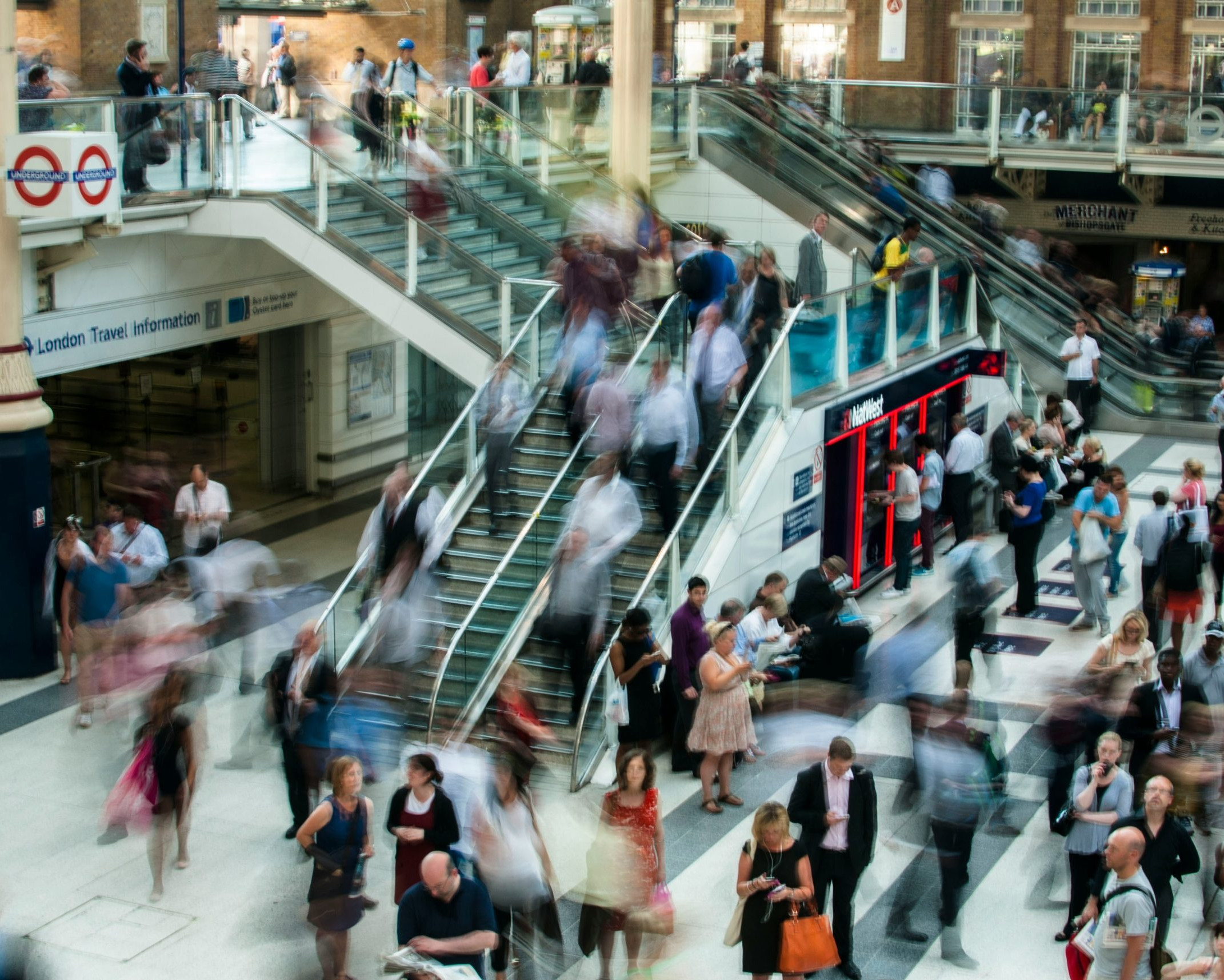 people on escalators in a crowded shopping mall